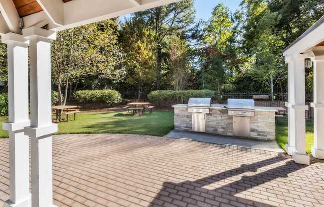 A patio with a white column and a stone wall.