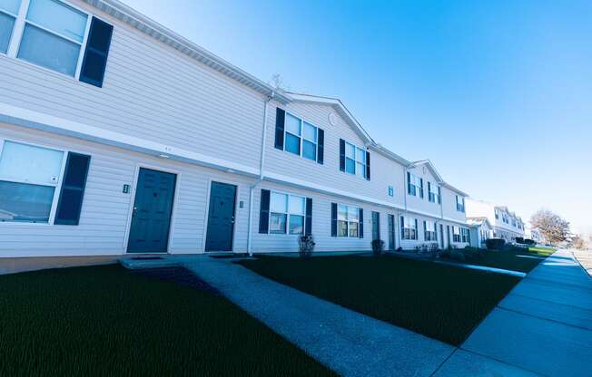 A long white house with a blue sky in the background.