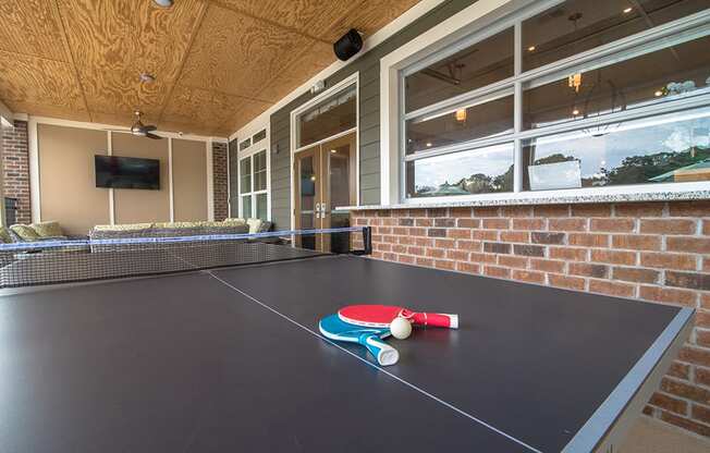 a ping pong table in front of a brick wall