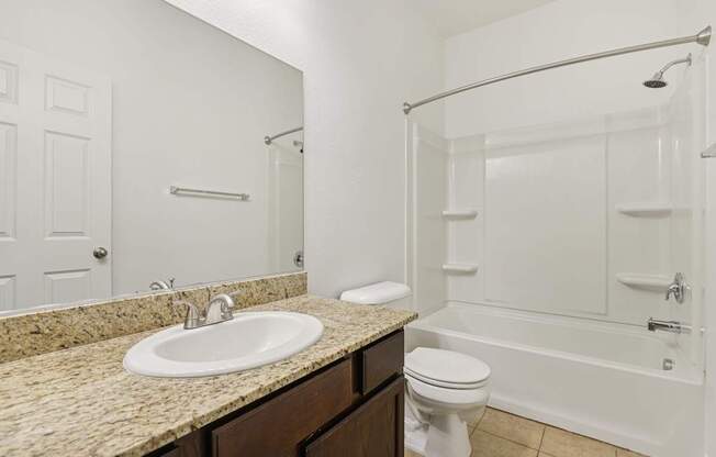 A bathroom with a sink, toilet, and bathtub.