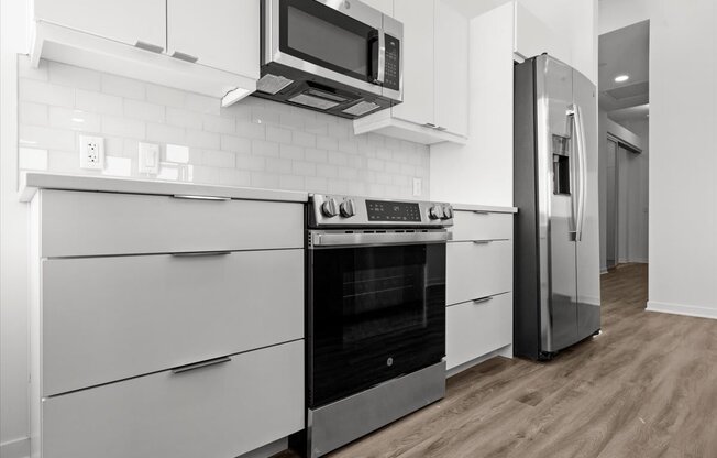 a kitchen with white cabinets and a stove and a refrigerator