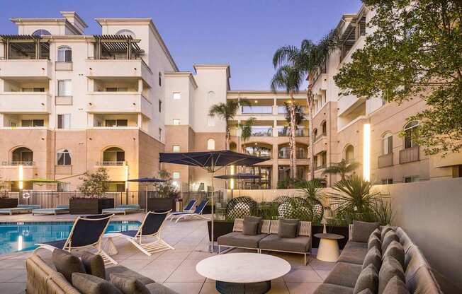 A large building with a pool and lounge chairs. at La Jolla Crossroads Apartments, California, 92122