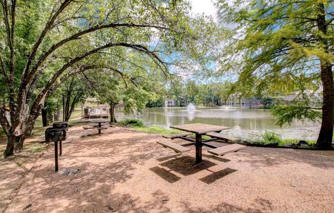 a picnic area with a picnic table next to a lake