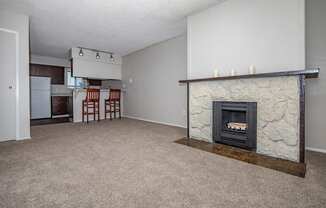 an empty living room with a fireplace and a kitchen at Lincoln Village Apartments, Spokane Washington