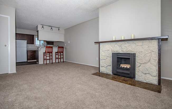 an empty living room with a fireplace and a kitchen at Lincoln Village Apartments, Spokane Washington