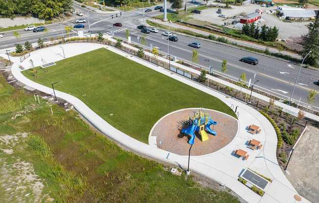 A playground with a blue and yellow structure in the middle of a green field.