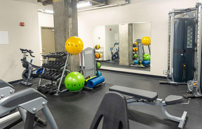 a gym with exercise equipment and mirrors in a building