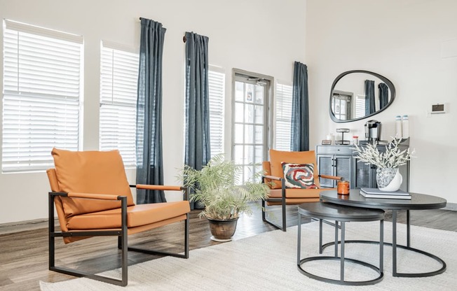 a living room with orange chairs and a coffee table
