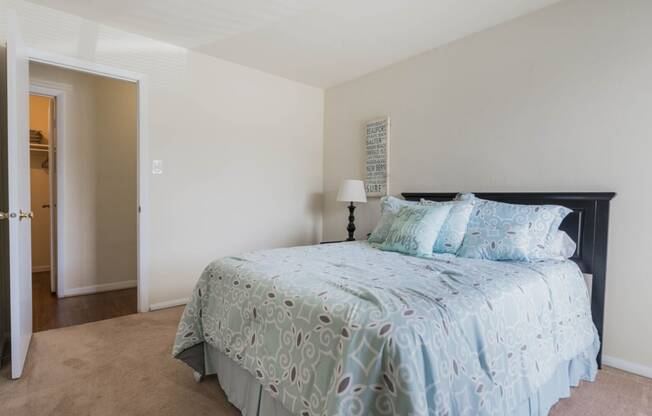 a bedroom with a bed and a door to a bathroom  at Bayville Apartments, Virginia, 23455