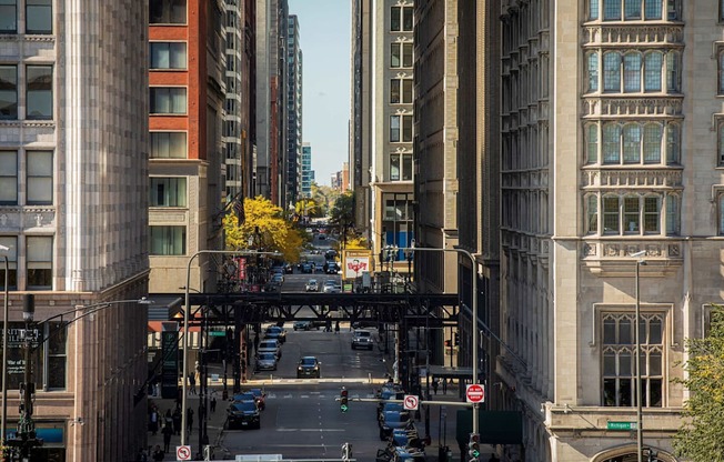 a view of a city street with tall buildings and a bridge