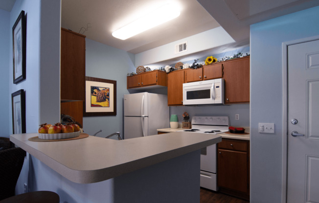 A kitchen with a counter and a fridge.