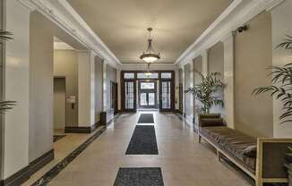 a hallway with a bench and plants and a chandelier at The Knights @ 506 Delaware Apartments, New York