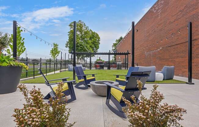 a patio with chairs and a fire pit