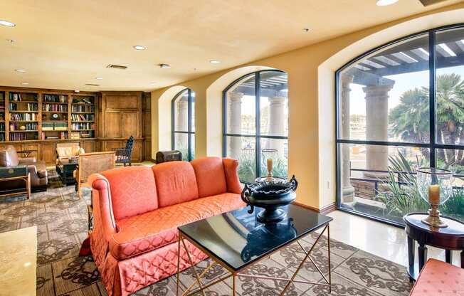 a living room with large windows and a orange couch  at Marina Harbor, Marina del Rey, 90292