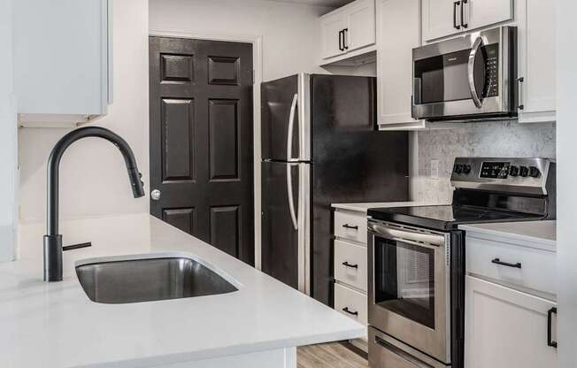 A modern kitchen with a black refrigerator and stove.
