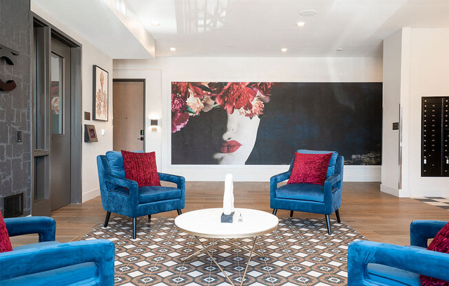 a living room with blue chairs and a large painting