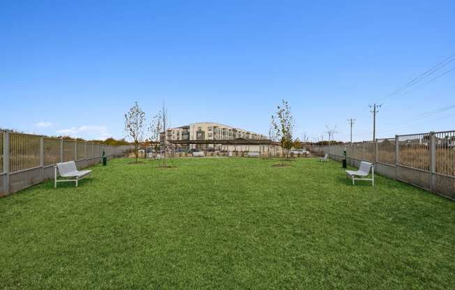 a yard with benches and a large building in the background at LynnCora, Grand Prairie, TX, 75052