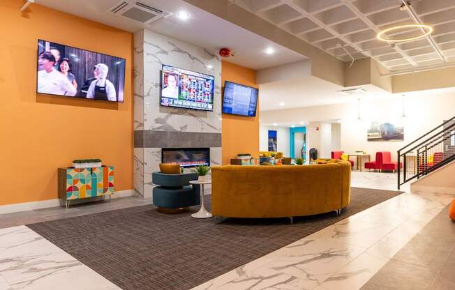 a lobby with a couch and a fireplace and a tv