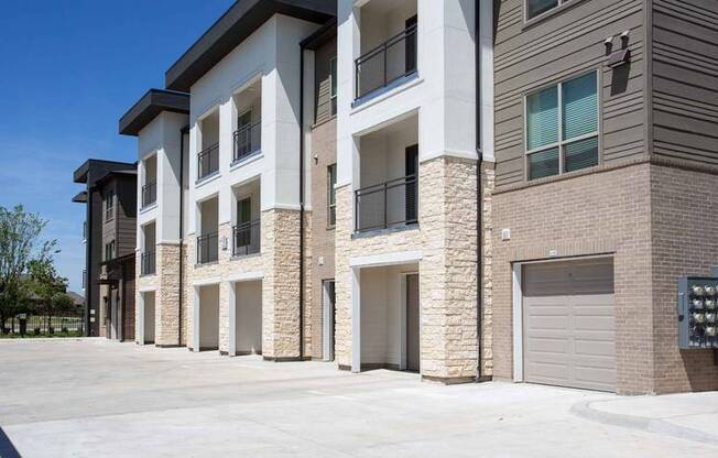 a row of brick apartment buildings with garage doors at Hunters Creek Apartments, Denton, TX