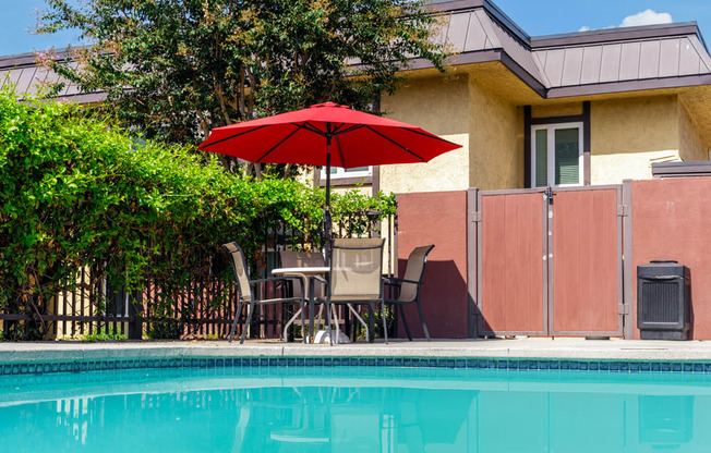 a swimming pool with an umbrella in front of a house