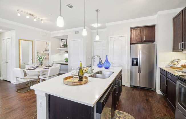 a kitchen with a large island and a stainless steel refrigerator