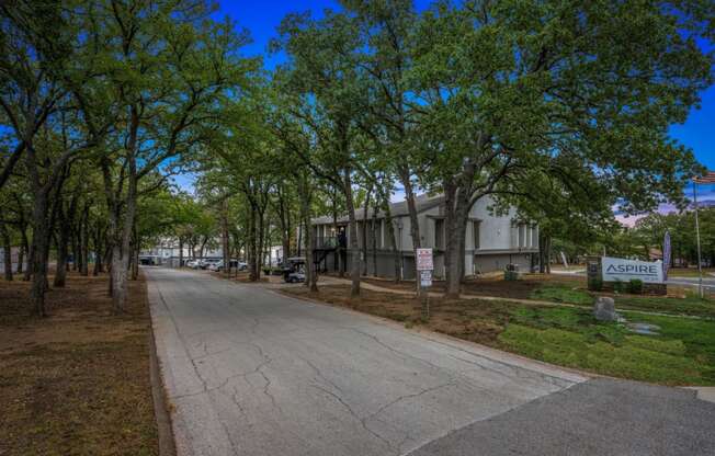 a street with a building and trees on both sides of it