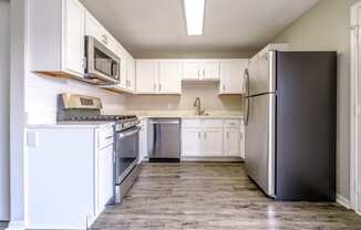 a kitchen with white cabinets and stainless steel appliances