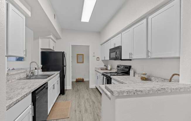 a kitchen with marble counter tops and white cabinets