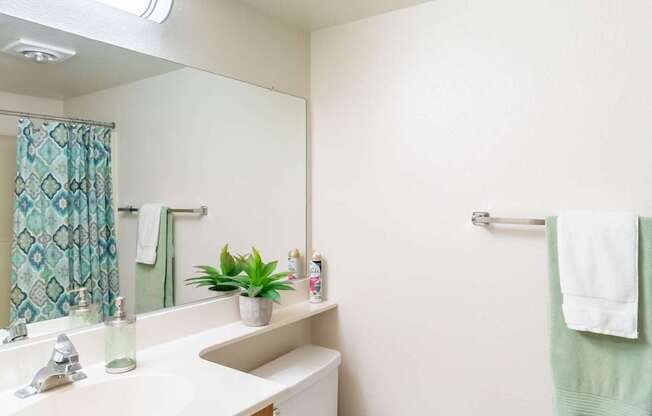 A white toilet sits in a bathroom next to a sink.
