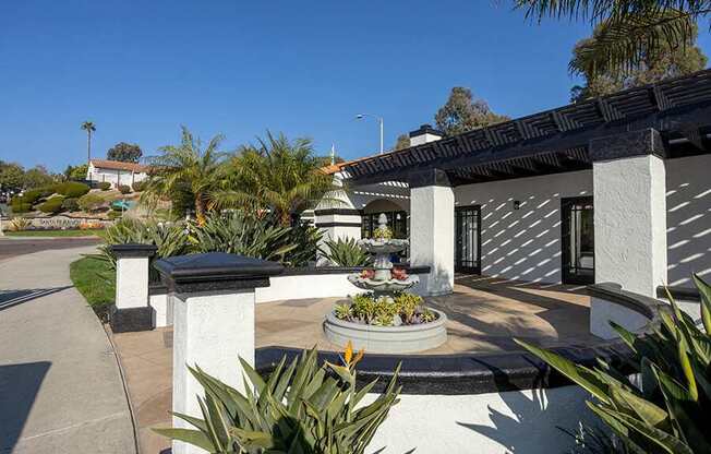 A house with a white fence and a small garden in front.