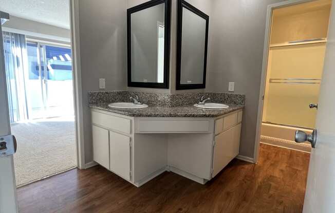 a bathroom with a sink and two mirrors