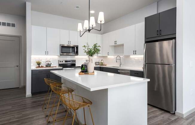 A modern kitchen with a white island and stainless steel appliances.