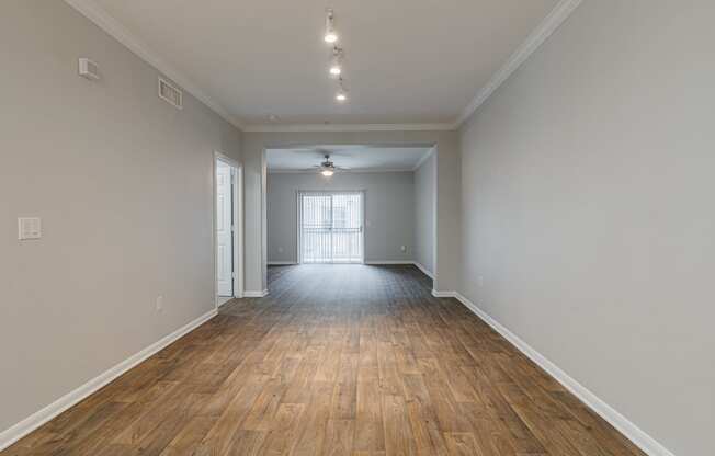the living room and dining room of an empty house with wood flooring