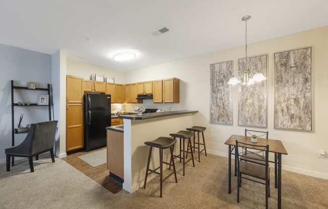 a kitchen with a bar and a dining room with a table and chairs