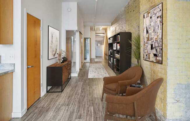 A room with a yellow brick wall and a long wooden floor.