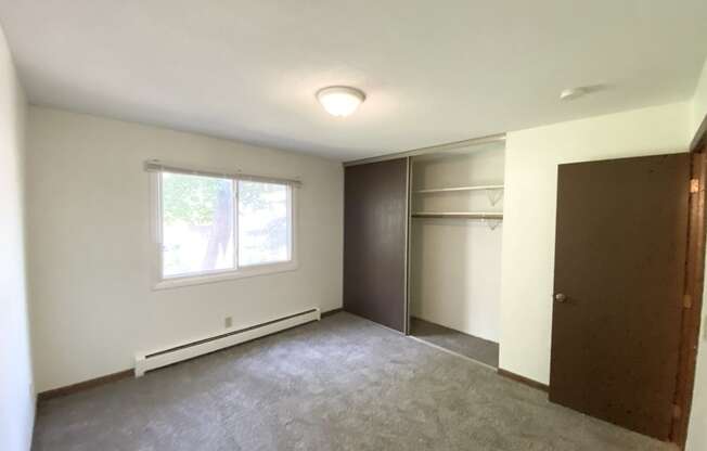 an empty room with a large window and white walls