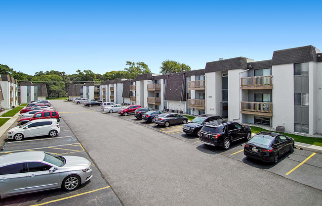 a row of apartment buildings with cars parked in front of them