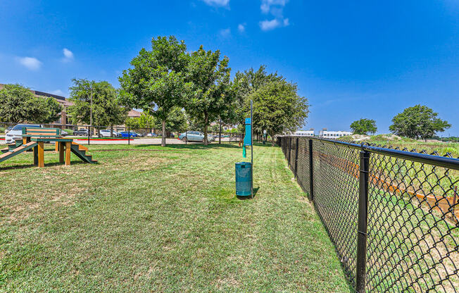 a chain link fence with a grassy field behind it and trees at Discovery at Craig Ranch, McKinney, TX