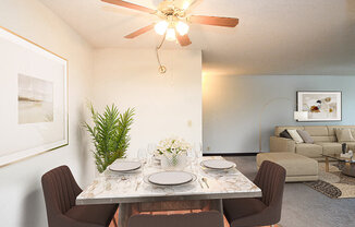 a dining room with a table and chairs and a ceiling fan