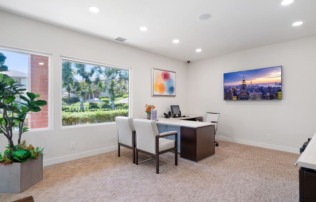 an office with a desk and chairs and a large window