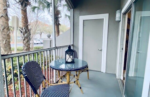 balcony with two chairs and a table and a door at Mainstreet Apartments, Clearwater