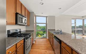 full kitchen with granite counter tops and stainless steel appliances and a window