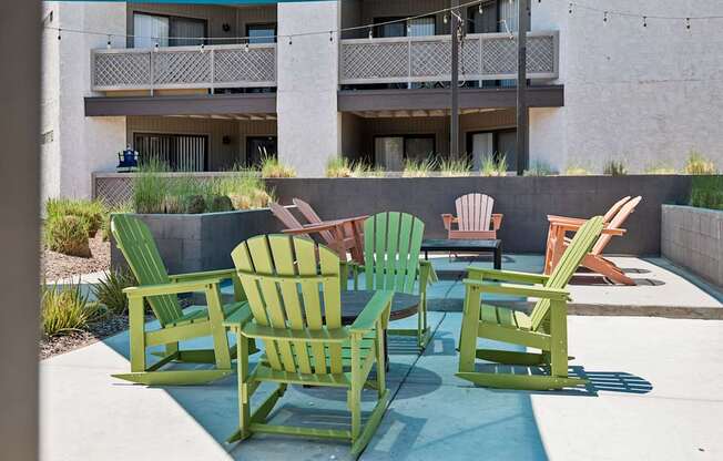 A group of green chairs are arranged on a patio.