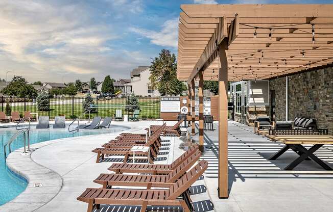 Relaxing pool area with lounge chairs at Hanover Flats in Bennington, NE