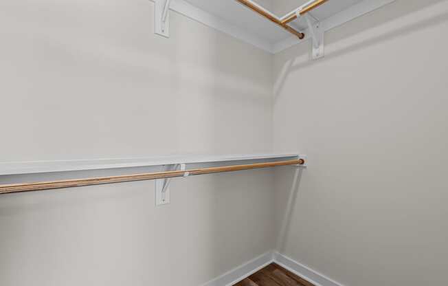 A white wall with a brown pipe and a white shelf.