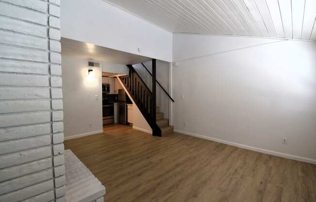 a view of a living room with wood floors and a staircase