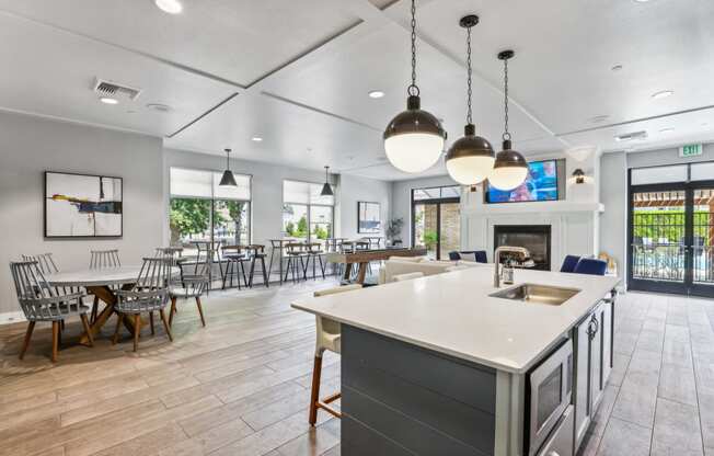 a communal kitchen and dining room with tables and chairs and a fireplace