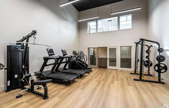 A spacious gym with a variety of equipment including treadmills, weight machines, and benches.