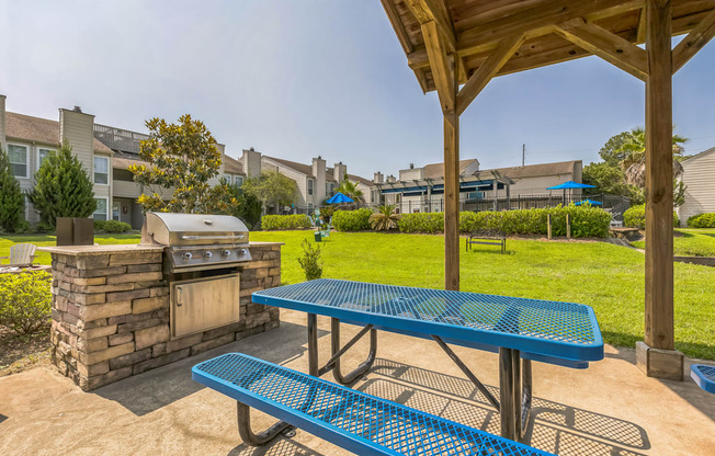 A blue picnic table is in the foreground of a residential area.