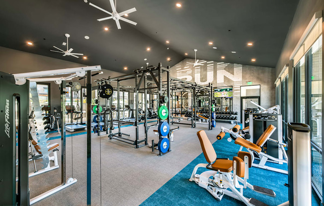a gym with weights and cardio equipment and a sign on the wall